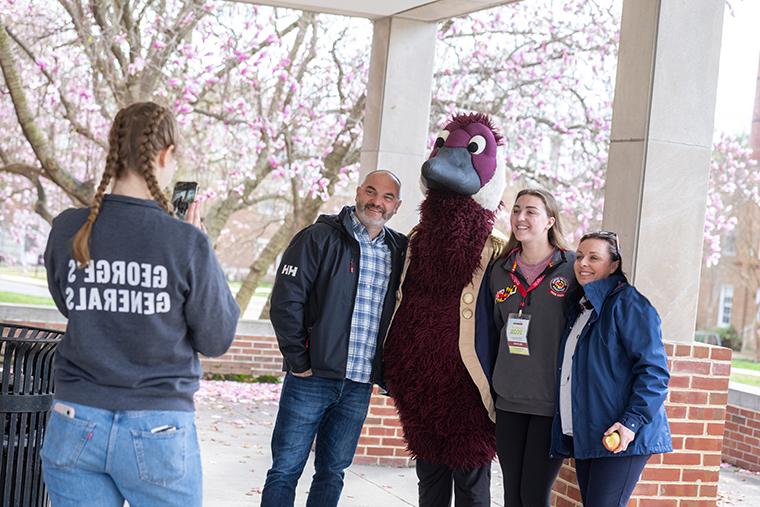 a family gets their picture taken with Gus the Goose mascot